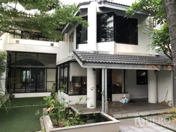 บ้าน ให้เช่าในBang Rak, Bangkok - มุมด้านหลังกว้างด้วยหน้าต่างกระจก เตียงระเบียงมีหลังคา และบ่อปลากลางสวน