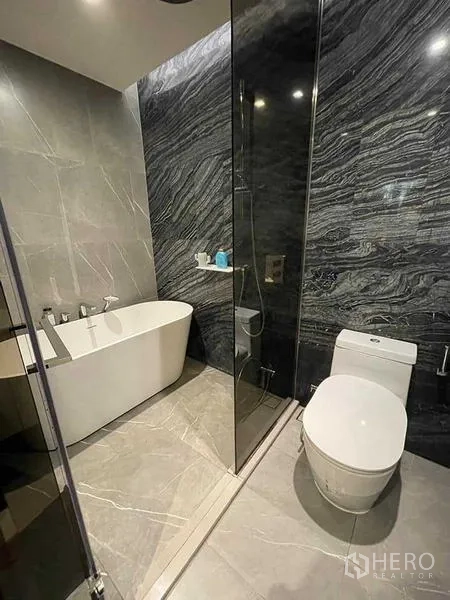 Condominium for rent or sale - Luxury bathroom with freestanding tub, glass shower and marble walls
