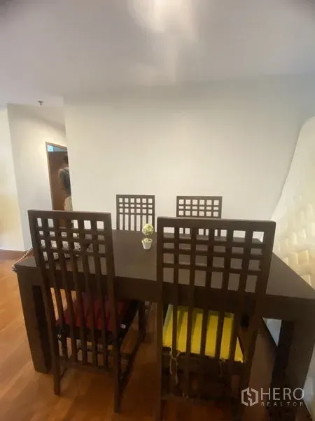 คอนโด ให้เช่าในPathum Wan, Bangkok - พื้นที่รับประทานอาหาร โต๊ะไม้สีเข้มพร้อมเก้าอี้พนักพิงสูงสี่ตัว บนพื้นไม้โทนอุ่น