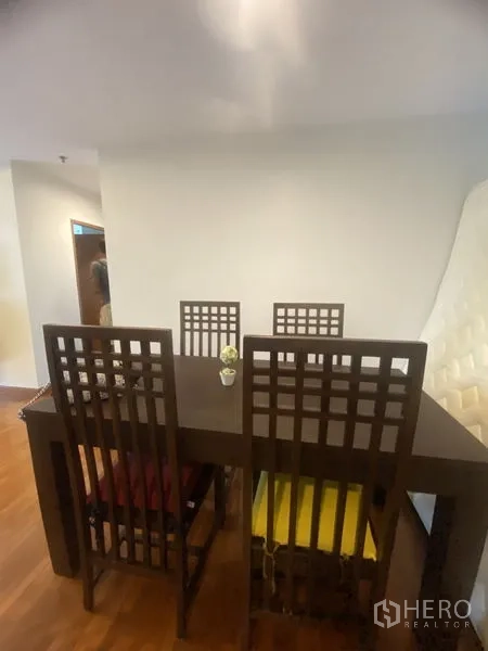 คอนโด ให้เช่าในPathum Wan, Bangkok - พื้นที่รับประทานอาหาร โต๊ะไม้สีเข้มพร้อมเก้าอี้พนักพิงสูงสี่ตัว บนพื้นไม้โทนอุ่น