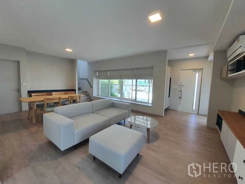 Townhouse for rent - Living room with large front window, entry door, and neutral decor.