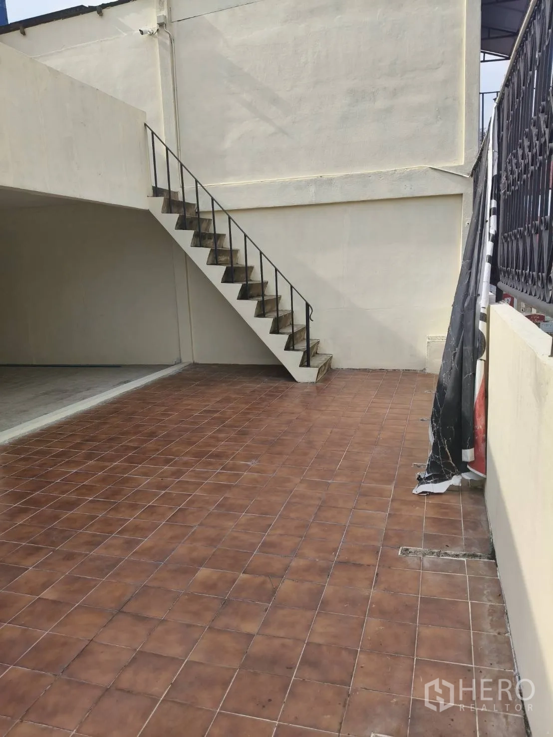 Retail Space for rent in Watthana, Bangkok - Outdoor tiled terrace with a metal staircase and high surrounding walls.