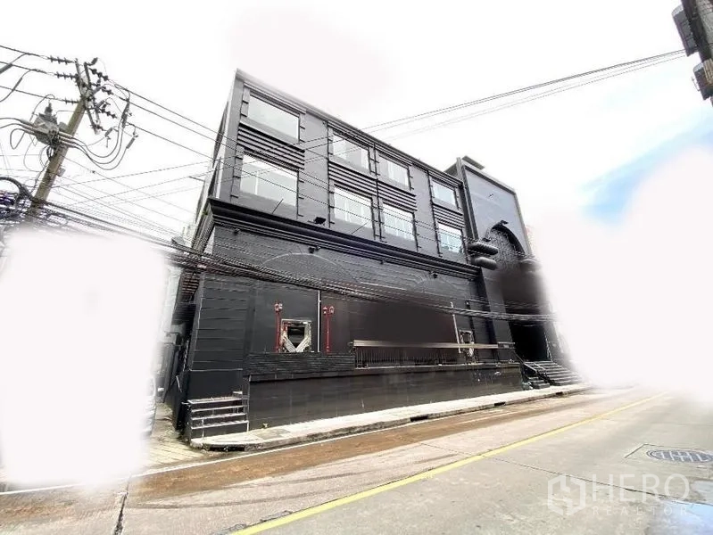 พื้นที่ขายปลีก ให้เช่าในKhlong Toei, Bangkok - มุมอาคารค้าปลีกสีดำสมัยใหม่ หน้าต่างบานใหญ่ ติดถนน เข้าออกสะดวก ใกล้รถไฟฟ้า