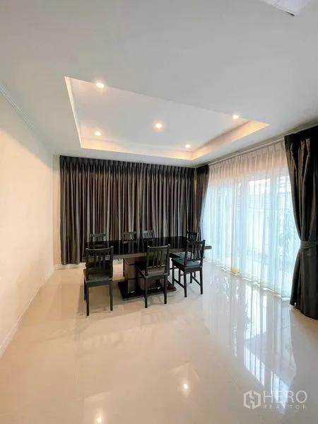 บ้าน ขายในBang Phli, Samut Prakan - ห้องทานอาหารแบบโอเพ่นสเปซ เพดานซ่อนไฟ และหน้าต่างสูงจรดพื้นพร้อมผ้าโปร่ง