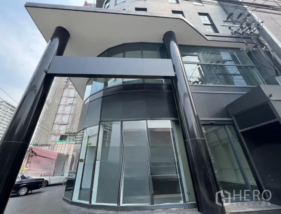 零售空间 出租在Watthana, Bangkok - 通罗区现代零售建筑外立面，黑色立柱与整面玻璃幕墙。