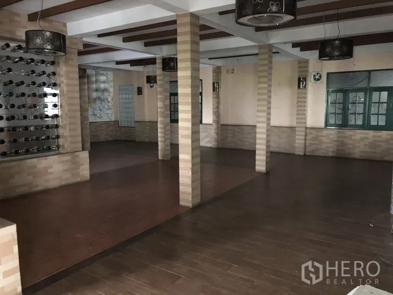 零售空间 出租在Khlong Toei, Bangkok - 开放式大厅，多根立柱、木纹地面、特色灯具与大窗