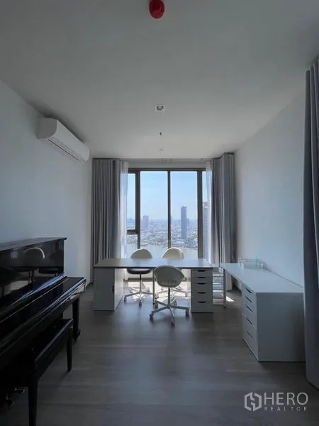 Condominium for rent in Bang Kho Laem, Bangkok - Study room with upright piano, twin workstations, and panoramic windows.