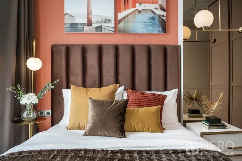 公寓 出租或出售在Watthana, Bangkok - 主卧搭配高靠背软包床头与温暖抱枕，床头灯柔和。