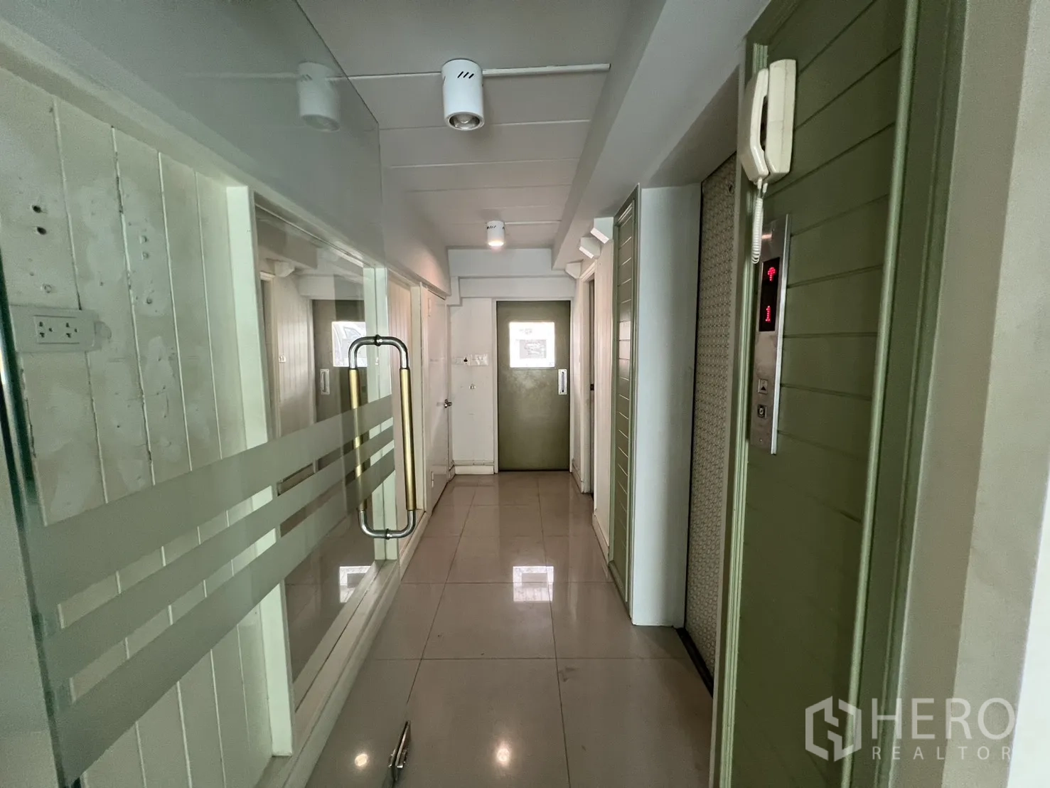 店屋 出租在Bang Rak, Bangkok - 室内走道配玻璃门、电梯与筒灯照明。