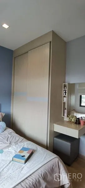 联排别墅 出租在Prawet, Bangkok - 卧室一角，内置推拉衣柜与梳妆台，色调柔和。