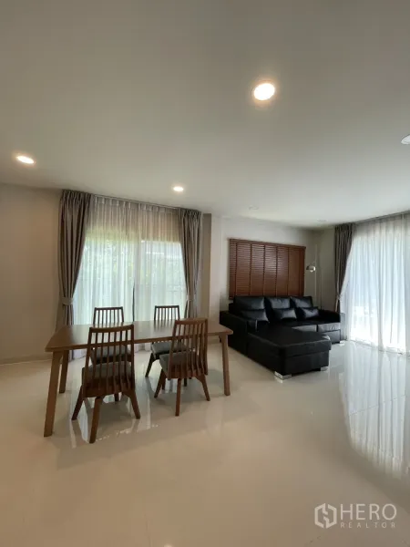 Detached House for rent in Bang Phli, Samut Prakan - Four-seat dining table beside lounge area with floor-to-ceiling sheer curtains.