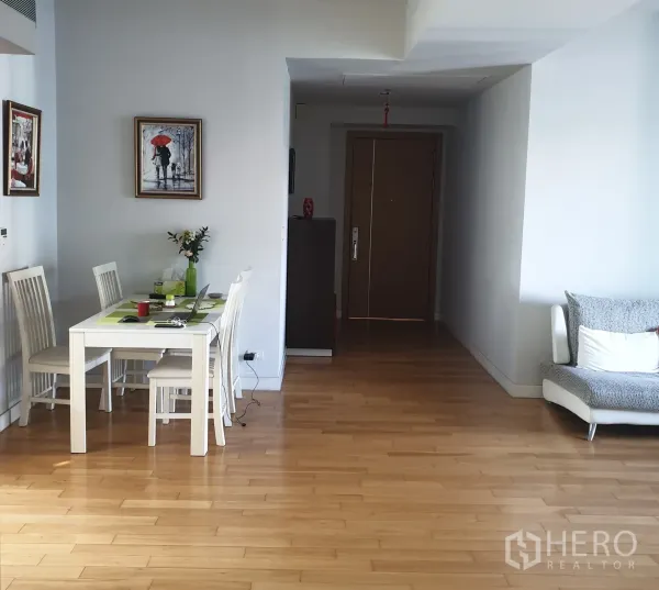 คอนโด ขายในKhlong Toei, Bangkok - มุมทานอาหารโต๊ะสีขาวข้างโถงทางเดินและโซฟา บนพื้นไม้เรียบ