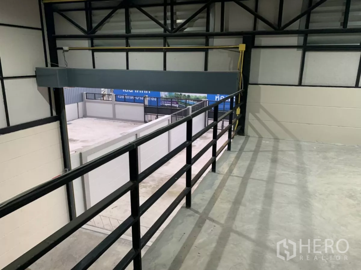 货栈 出租在Bang Bua Thong, Nonthaburi - 夹层视角俯瞰装卸区，金属栏杆与高钢桁架屋顶清晰可见。