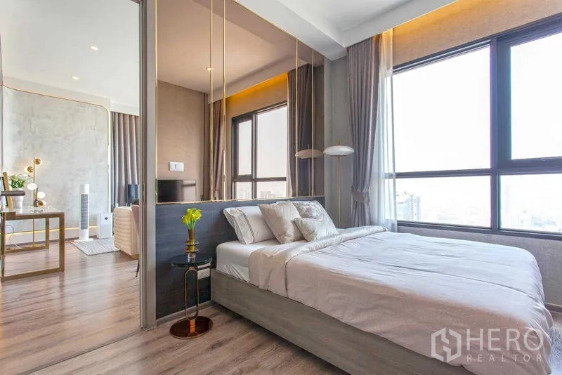 Condominium for rent in Watthana, Bangkok - Second bedroom with windows on two sides, pendant lamps and skyline views.