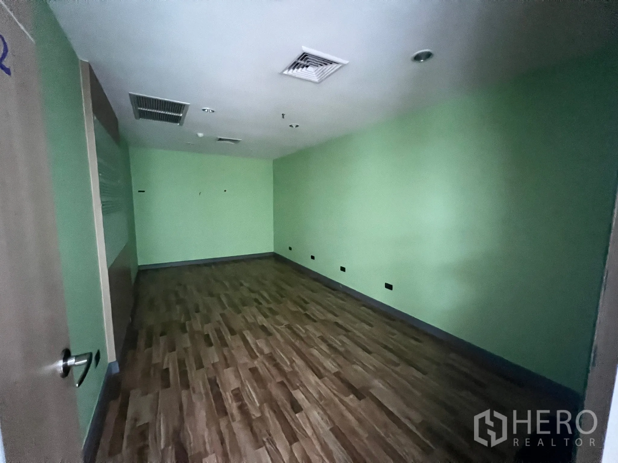 零售空间 出租 - 分隔大房，绿色墙面、仿木地板与吊顶空调出风口。