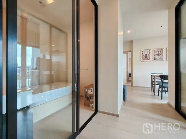 Condominium for rent - Hallway with glass-walled bedrooms on both sides leading to a bright dining area.