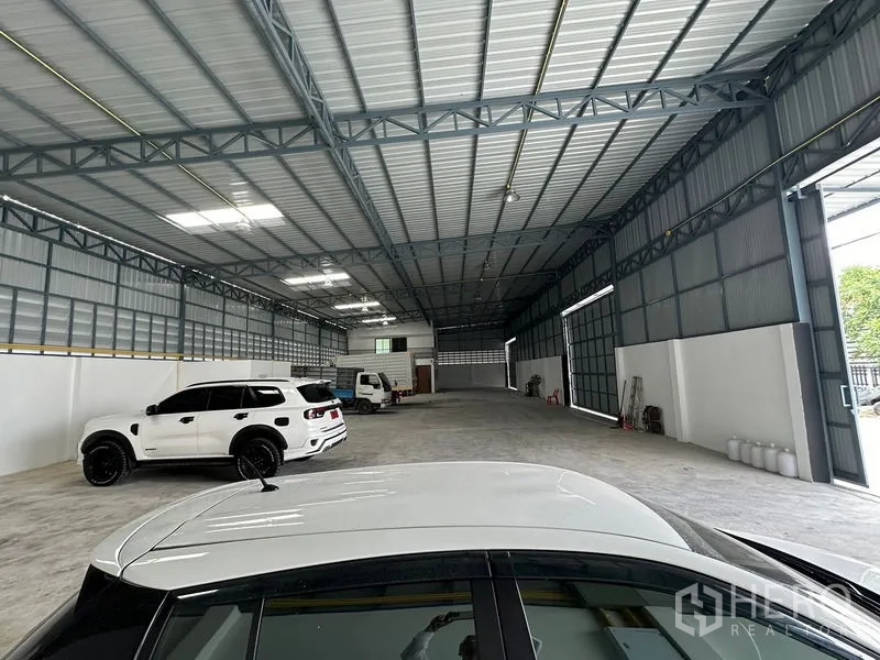 คลังสินค้า ให้เช่าในLam Luk Ka, Pathum Thani - มุมมองลึกภายในโกดัง หลังคาเหล็ก ช่องระบายอากาศข้าง และรถจอด