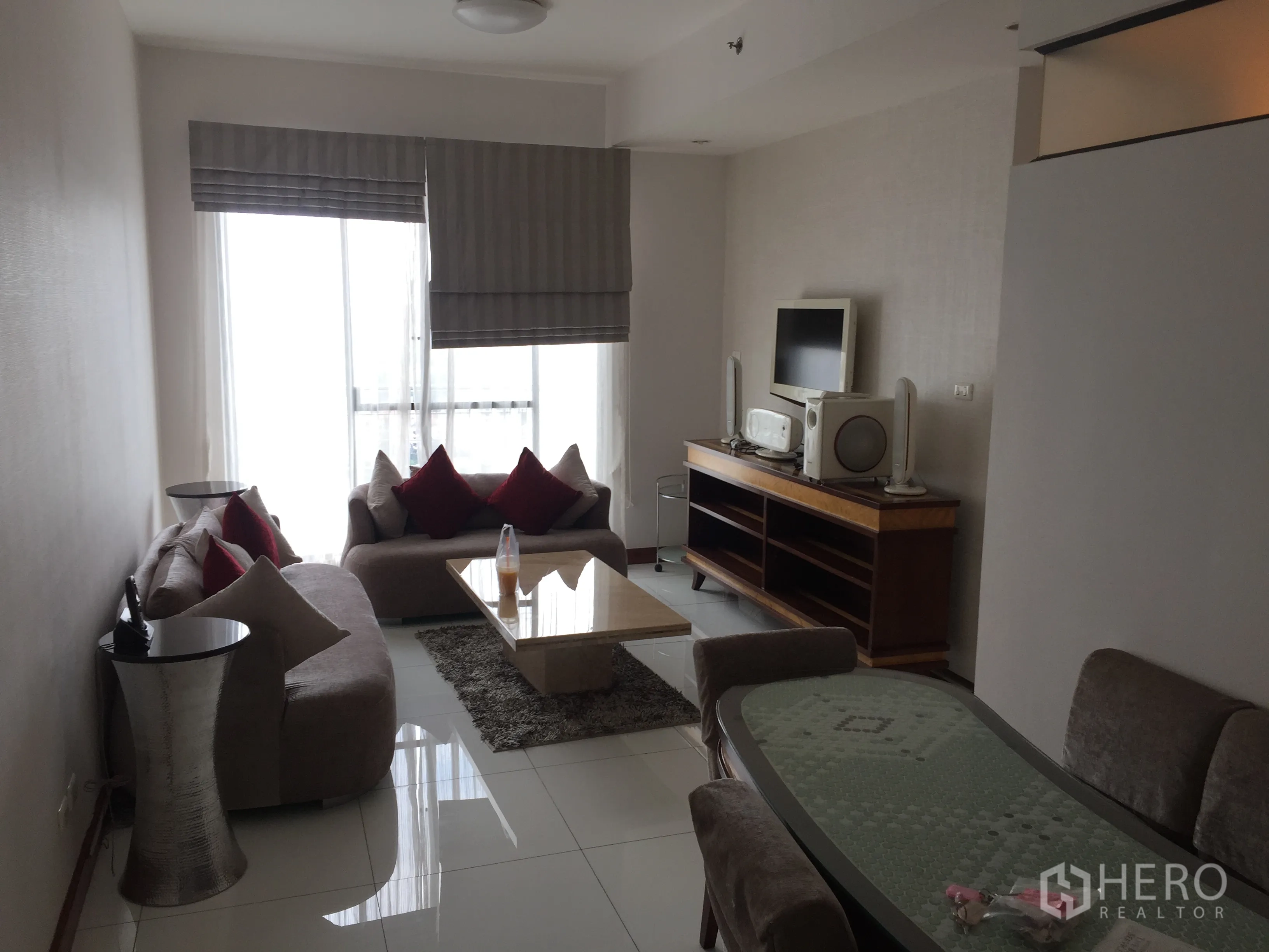 คอนโด ให้เช่าในWatthana, Bangkok - ห้องนั่งเล่นสว่าง โซฟา โต๊ะกลาง และชั้นวางทีวีข้างหน้าต่างบานใหญ่