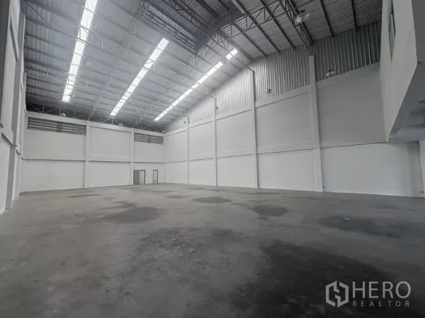 Factory for rent in Phra Samut Chedi, Samut Prakan - Clear-span production floor with polished concrete and skylight strips along the roof.