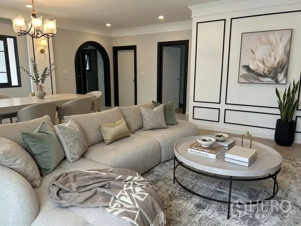 Detached House for rent in Bang Phli, Samut Prakan - Open-plan living area with a large sectional sofa, coffee table, and wall moulding detail.
