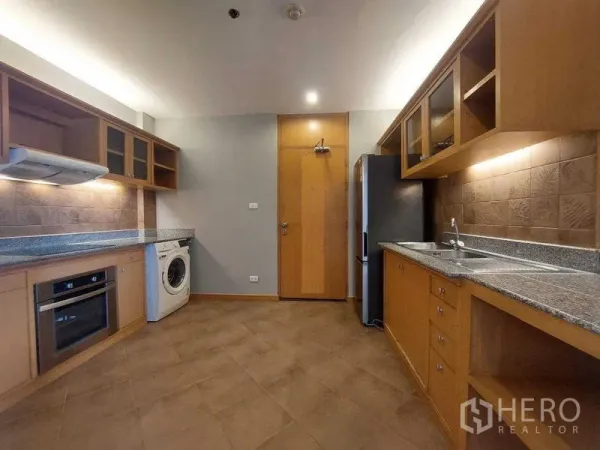 房间 出租 - 宽敞厨房，木柜、花岗岩台面、嵌入式烤箱、洗衣机与冰箱。