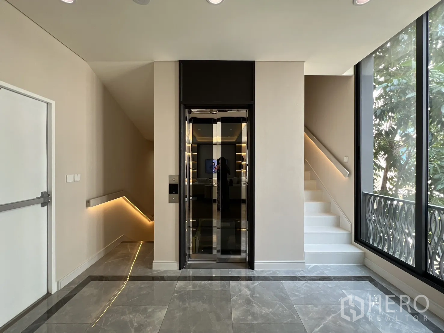 Semi-detached House for sale in Yan Nawa, Bangkok - Landing area with glass home lift, stairs, and tall windows.