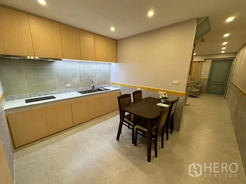 ทาวน์เฮาส์ ให้เช่าในPhra Khanong, Bangkok - ครัวบิวท์อิน ตู้ไม้โทนอ่อน เตาไฟฟ้า อ่างล้างจาน และโต๊ะทานข้าว 4 ที่นั่ง