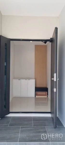 บ้าน ให้เช่าในSaphan Sung, Bangkok - โถงทางเข้าหน้าบ้าน ประตูคู่ ตู้เก็บรองเท้า และผนังลายไม้แนวตั้ง