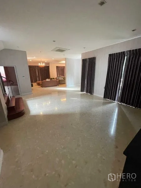 Detached House for sale in Mueang Samut Prakan, Samut Prakan - Open living hall with marble floors, dark drapes and view toward a seating area.