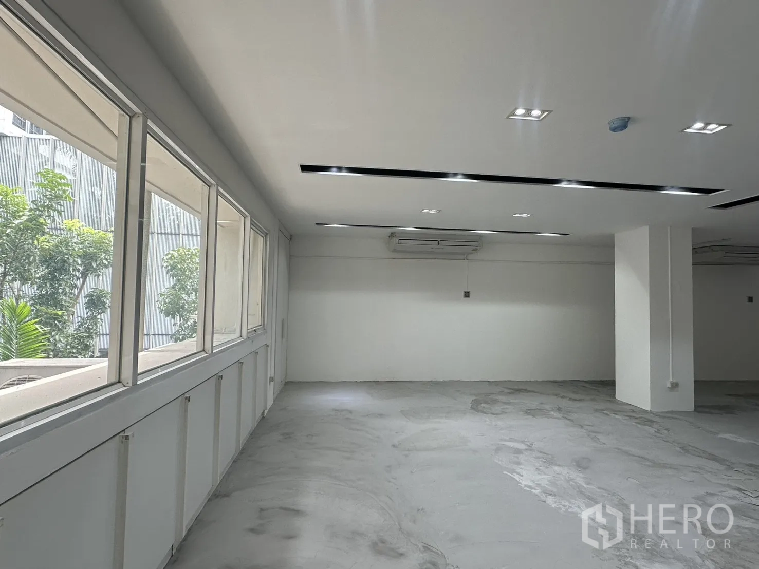 ออฟฟิศ for rent in Pathum Wan, Bangkok - แนวหน้าต่างบานใหญ่เห็นต้นไม้ภายนอก พร้อมเครื่องปรับอากาศแบบแขวนผนัง