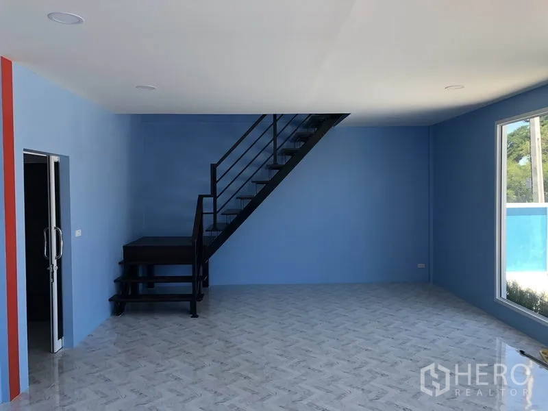 货栈 出租或出售在Sai Noi, Nonthaburi - 一层办公室，蓝色墙面，大窗，通往二层的黑色金属楼梯。