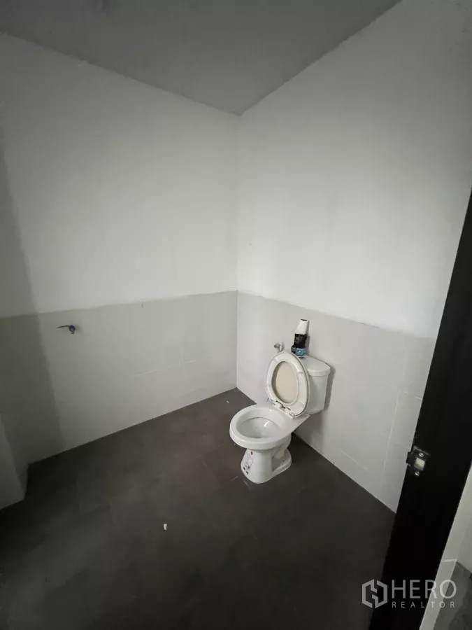 店屋 出租在Watthana, Bangkok - 简洁卫生间，坐便器与半高瓷砖墙。