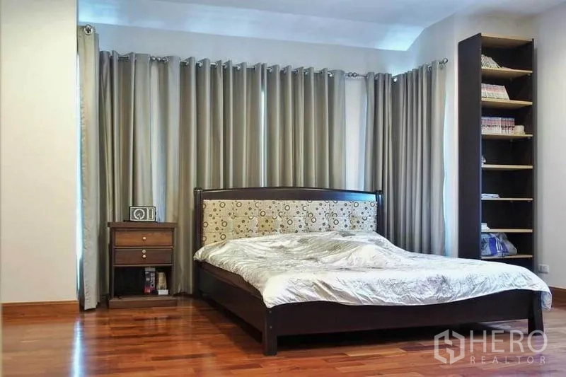 独立式住宅 出租或出售在Pak Kret, Nonthaburi - 次卧明亮，带高书架、全遮光窗帘与木地板。