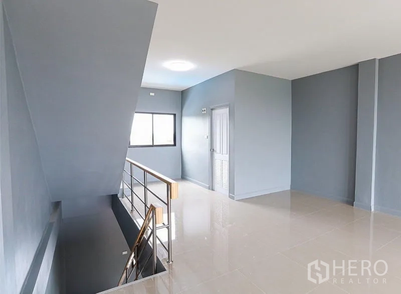 Shophouse for sale in Lam Luk Ka, Pathum Thani - Upper-floor corridor with window and storage access under the stairs.