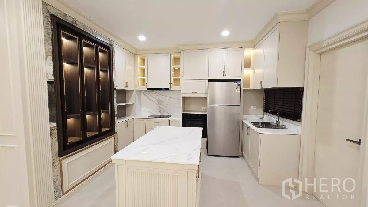 Detached House for rent in Prawet, Bangkok - Western kitchen with island, white cabinetry and stainless steel appliances.