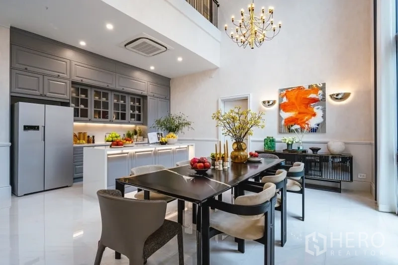 บ้าน ขายในBang Kapi, Bangkok - ครัวและพื้นที่ทานอาหารสไตล์กูร์เมต์ มีไอส์แลนด์ ตู้สีเทา และโคมระย้า เพดานสูงสองชั้น