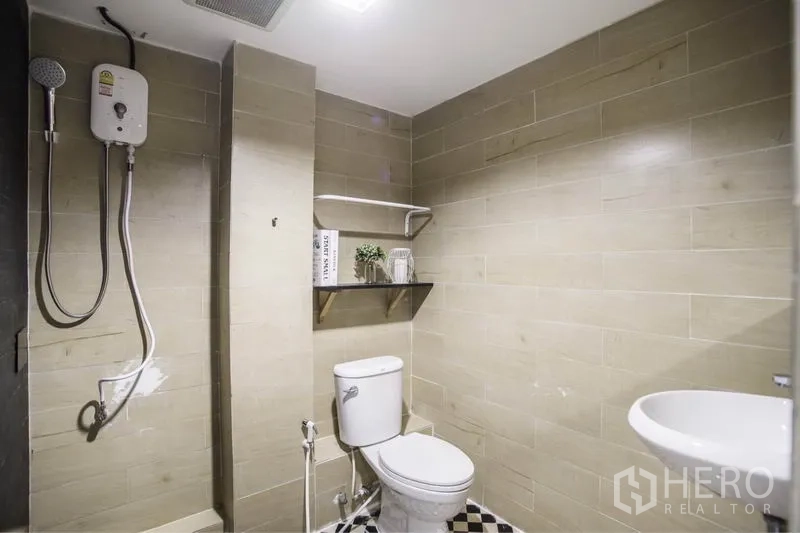 ทาวน์เฮาส์ ให้เช่าในKhlong Toei, Bangkok - ห้องน้ำกระเบื้องสีเบจ ฝักบัวเครื่องทำน้ำอุ่น โถสุขภัณฑ์ และชั้นวาง
