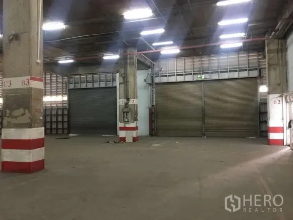 Warehouse for rent in Khlong Toei, Bangkok - Interior loading zone with multiple large roller shutter doors for trucks.