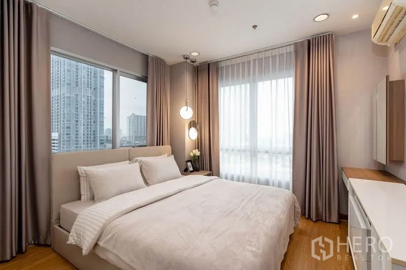 คอนโด ให้เช่าในPhaya Thai, Bangkok - ห้องนอนมาสเตอร์มุมอาคารมีหน้าต่างสองด้าน ผ้าม่านโปร่ง และโคมแขวน