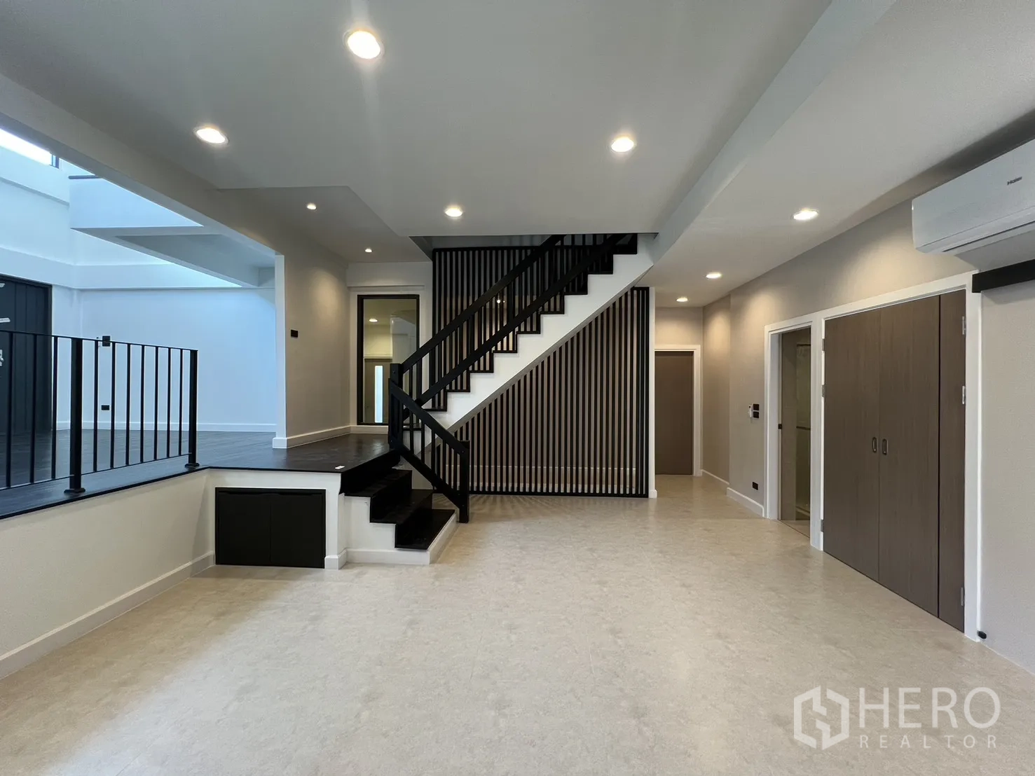 บ้าน ให้เช่าในSaphan Sung, Bangkok - พื้นที่นั่งเล่นแบบโอเพนเพลน พื้นเล่นระดับ บันไดสีดำและระแนงไม้แนวตั้ง