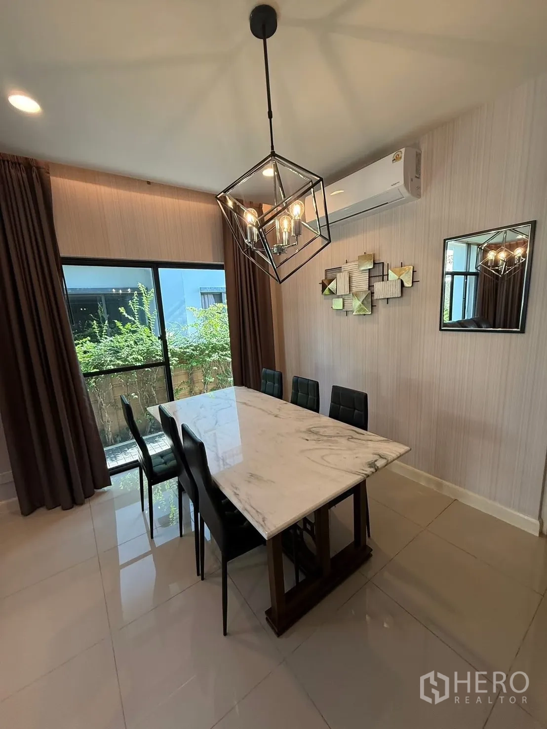 Detached House for rent in Prawet, Bangkok - Dining room with marble-top table, six chairs and a geometric pendant light.