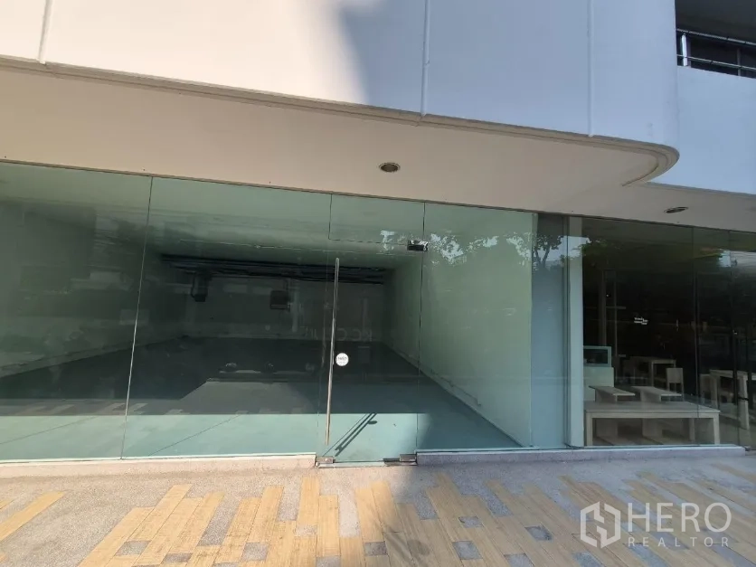 零售空间 for rent in Watthana, Bangkok - 一层临街商铺，整面落地玻璃与单开玻璃门，适合设置招牌。