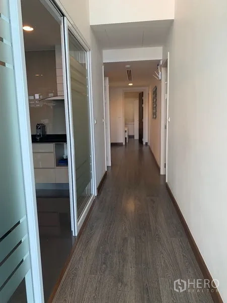 คอนโด ให้เช่าในPathum Wan, Bangkok - โถงทางเดินพื้นไม้ยาวติดครัวกั้นกระจก