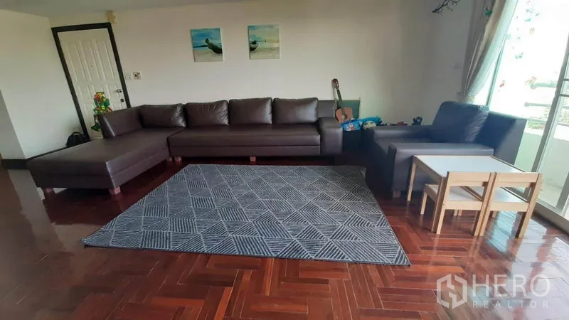 คอนโด ให้เช่าในWatthana, Bangkok - มุมนั่งเล่น โซฟารูปตัวแอล ชุดโต๊ะเล็ก และประตูกระจกบานเลื่อนออกสู่ระเบียง