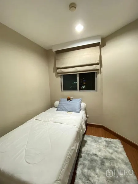 Condominium for rent - Small bedroom with single bed, city-view window, and soft area rug.