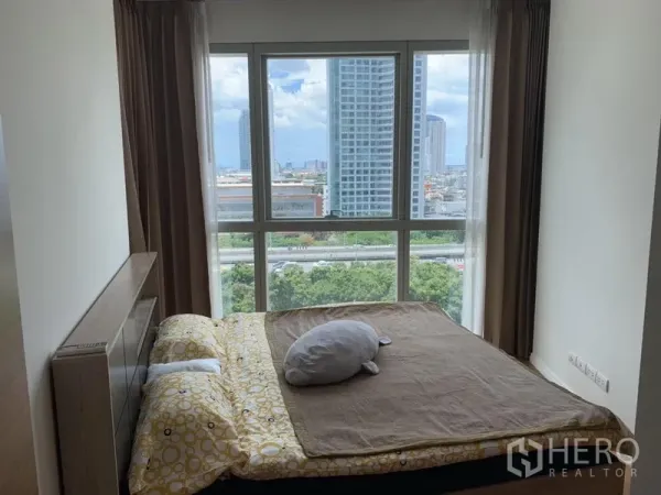 公寓 出租或出售在Khlong San, Bangkok - 采光充足的卧室，大窗户可观城市天际线与绿意景观。