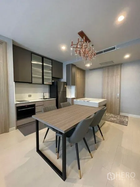 Condominium for rent in Pathum Wan, Bangkok - Open-plan kitchen and dining area with a four-seat table and chandelier.