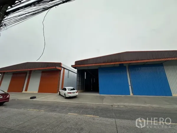 货栈 出租在Bueng Kum, Bangkok - 成排仓库，前方混凝土前院与道路出入口。