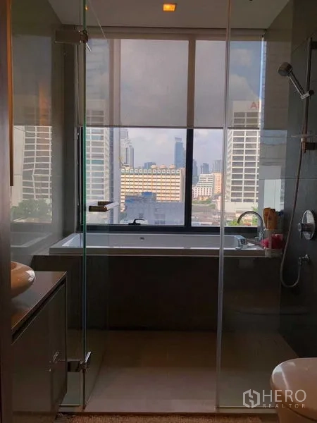 公寓 出租在Bang Rak, Bangkok - 玻璃淋浴间对面是靠窗浴缸，可观城市天际线。