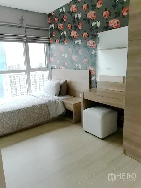 Condominium for rent in Khlong Toei, Bangkok - Second bedroom with floral feature wall, vanity desk and large window with city outlook.
